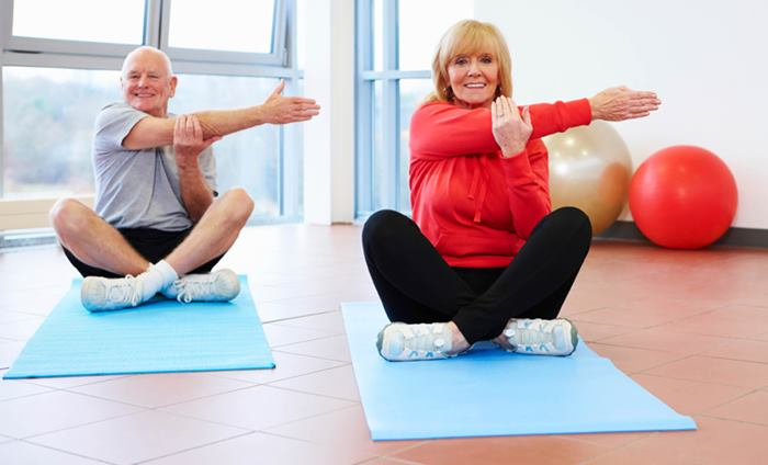 SferaFitnes coach exercising together with two older adults in a seated fitness class